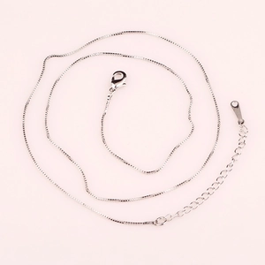 Detail of silver box chain necklace featuring a lobster clasp and adjustable link extension