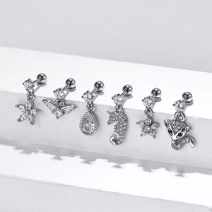 Polished steel cartilage studs with zircon fox and seahorse charms on white steps
