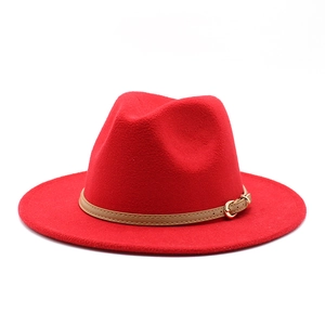 Detailed shot of a red wool felt fedora featuring a tan leather band and gold buckle