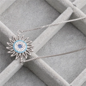 Silver sunflower pendant necklace with blue cubic zirconia on a velvet display box