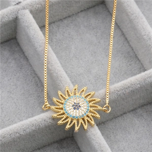 Detailed macro view of a gold sunflower evil eye bracelet with blue zircons in a box