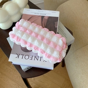 Pink and white bubble textured cosmetic pouch placed on a Kinfolk lifestyle magazine