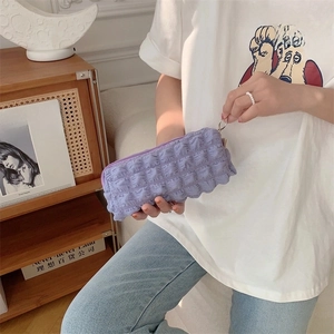 Close-up of a purple puffy pencil case with textured bubble pleats and metal ring detail