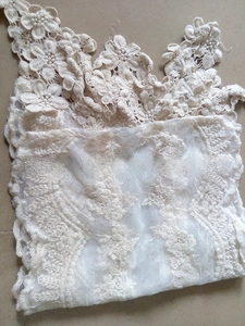Close-up of intricate white floral lace embroidery on a forest style long scarf detail