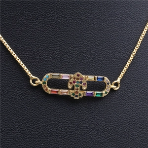 Dettaglio della collana con ciondolo a cerniera dorata e gemme colorate micro-incastonate
