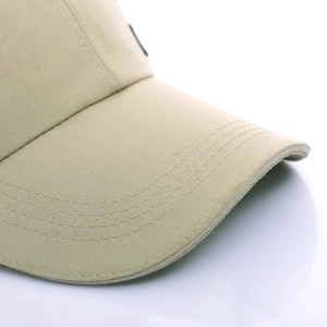 Beige cotton canvas baseball cap featuring reinforced visor stitching and side badge detail