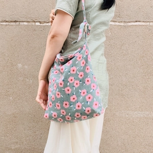 Detail of adjustable strap with wooden ring buckle on green floral corduroy bag