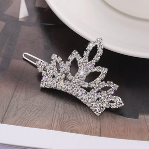 Macro shot of silver crown hair clip with sparkling rhinestones on dark background