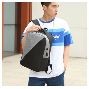 Close-up of gray and black crossbody bag with integrated USB charging port for travel