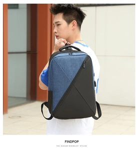 Blue and black oxford backpack with external USB port shown worn by model outdoors