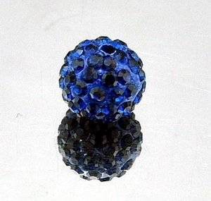 Macro view of blue rhinestone encrusted 10mm pavé clay bead on a reflective surface