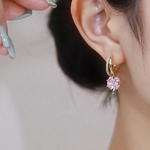 Macro shot of pink clover pearl earrings featuring gold hoops and zircon inlay