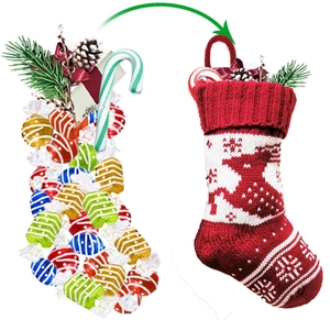 Detail of red and white knitted Christmas stocking with reindeer pattern and candy filling