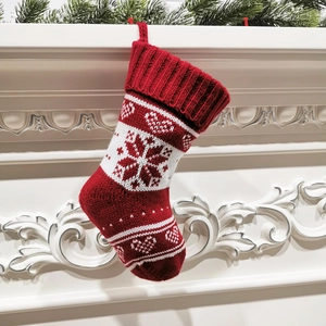 Close-up of knitted Christmas stocking with snowflake patterns hanging on fireplace