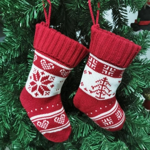 Detail of red and white knit Christmas stockings with snowflake patterns on a tree