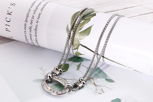 Detail of silver-toned double-layered chain with a sparkling rhinestone oval pendant