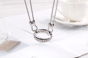 Close-up of double-layer silver titanium steel necklace with oval rhinestone pendant