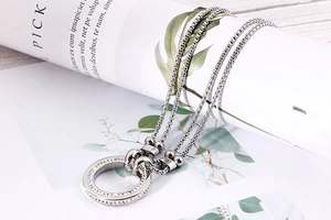 Detailed view of silver double-circle pendant necklace with sparkling zircon inlay