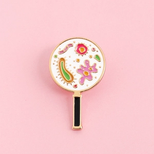 Cartoon magnifying glass enamel pin with colorful microbes and gold plating finish
