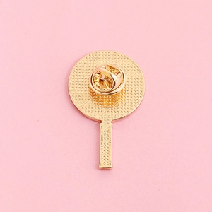 Macro detail of the gold-plated metal back of a brooch with a secure butterfly clutch