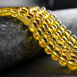 Strands of round translucent yellow amber glass beads for jewelry making