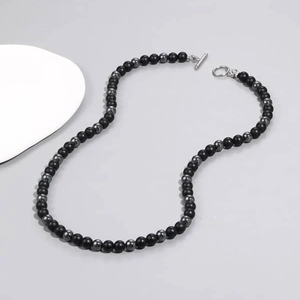 Close-up of black obsidian and hematite beaded necklace with a silver T-bar clasp detail