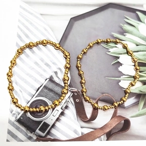 Pulseras clásicas de cuentas en acero inoxidable oro 18K sobre bandeja blanca vintage