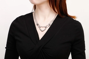 Close-up of double layer stainless steel heart pendant necklace on female model