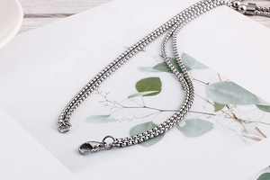 Close-up of silver stainless steel box chain necklace with lobster clasp detail