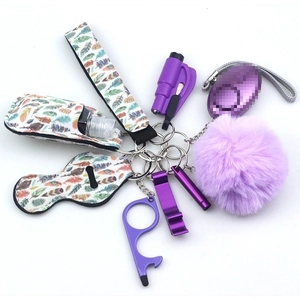 Detailed purple self-defense keychain set with alarm, wristlet, and pompom on white background