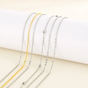 Three-layer stainless steel chain necklace in silver and gold with decorative metal beads