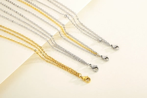 Detailed macro view of gold and silver stainless steel chain necklaces with lobster clasps