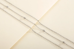 Detailed view of silver stainless steel satellite chain necklace with polished beads