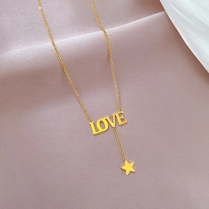 Detailed view of the gold LOVE letter pendant with a star charm on a delicate chain