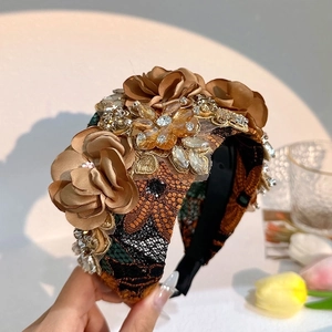 Close-up of handmade fabric flower headband with sparkling rhinestones and lace detail