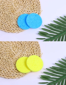 Macro detail of blue and yellow natural wood pulp facial cleansing sponges on a woven mat