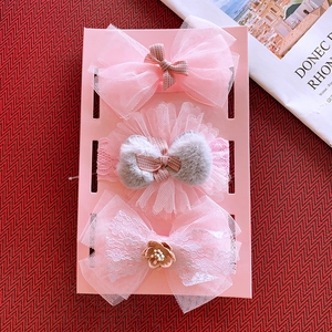 Close-up of three-piece pink bow baby headband set displayed on a card with lace and tulle