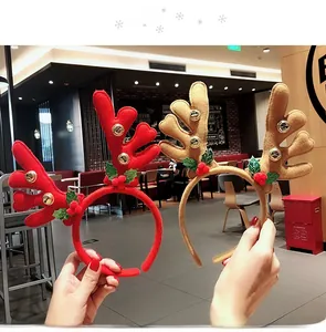 Detail of red and brown plush reindeer antlers headbands with bells and holly leaves