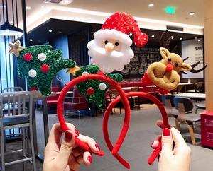 Close-up of festive Christmas headbands with plush Santa, reindeer, and sequined tree