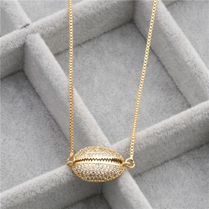 Detail of shell pendant with pavé zircon settings on a gold-tone copper necklace