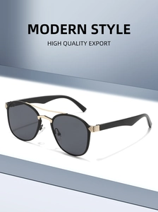Detail view of retro oval sunglasses with black alloy frame and gold double bridge design