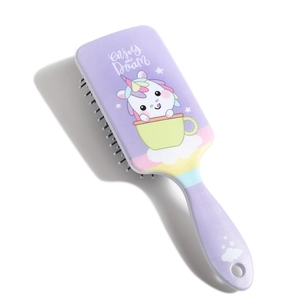 Detail of purple paddle brush featuring a cute unicorn in a teacup and Dream text