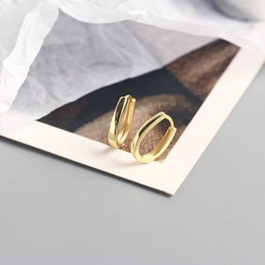 Detail of 18K gold minimalist rectangular hoop earrings with polished mirror finish