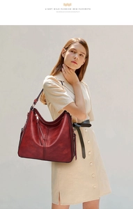 Deep red leather hobo bag on shoulder showing large capacity and soft drape
