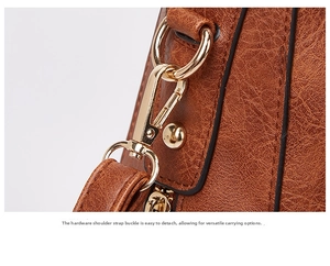 Close-up of brown litchi leather texture with polished gold metal shoulder strap buckle