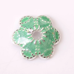 Gros plan sur une perle fleur vert clair pailletée pour la création de bijoux DIY