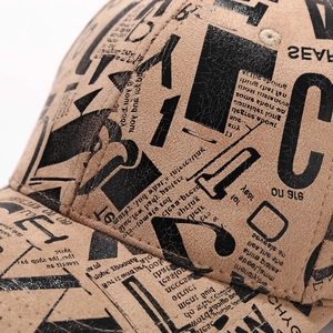 Detailed macro view of vintage graffiti print and stitching on a tan baseball cap