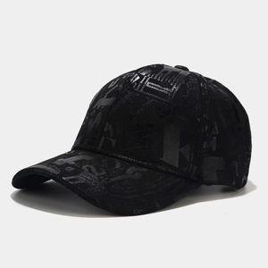 Close-up of black baseball cap featuring glossy graffiti letter patterns and street style