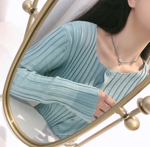 Detail of light blue ribbed knit cardigan with V-neck and single-breasted button design