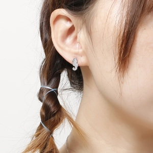 Silver seahorse stud earrings in stainless steel on model with clean white background